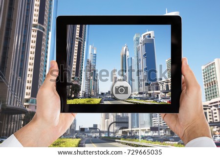 Close-up Of Person's Hand Holding Tablet Taking Pictures Of City Skyscrapers In Dubai