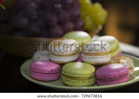 Close up of colorful pasta dessert with vintage pastel tones and a bunch of grapes on a plate.
