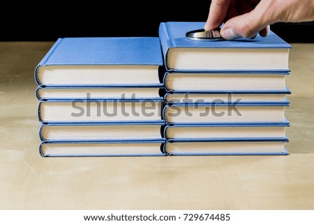Heap of books reading on a wooden table. Beside lies and stethoscope. Black background.