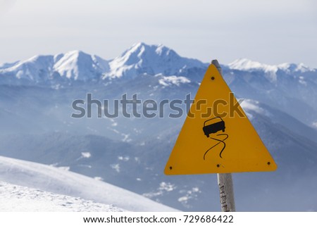 Slippery road sign, during snowy winter, in the mountainous region of Evritania, in Central Greece. 
