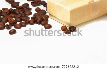 Gold gift boxes with ribbon and coffee beans on white background.