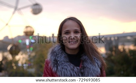Pretty young smiles woman enjoys city park