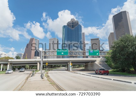 Downtown Houston from Allen Parkway near Sabine street under cloud blue sky. Highway/expressway in front of skyscrapers from central business district. Transportation, architecture and travel concept