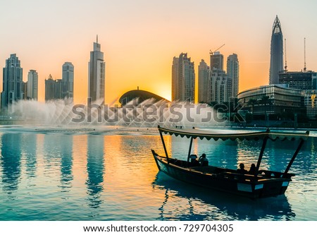 Singing fountains in Dubai. Dubai promenade singing fountains on the background of architecture. Dubai. In the summer of 2016. Royalty-Free Stock Photo #729704305