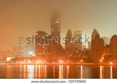 New York City skyline along the east side of Manhattan on a foggy night.