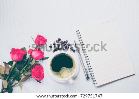 Morning Cup of coffee, empty notebook and roses flowers on white table from above. Cozy Breakfast. Flat lay style.coffee bean