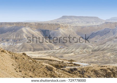 Rocky hills of the Negev Desert in Israel. Breathtaking landscape of the rock formations in the Southern Israel. Dusty mountains interrupted by wadis  and deep craters.
