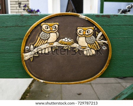 a plate with two owls sitting on a branch