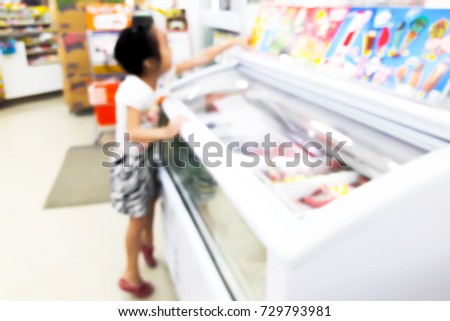 Inside the convenience store, blur image of children are shopping for ice cream as background.