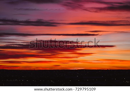 Spectacular sunset over Izhevsk. Orange and red clouds with city silhouette on horizon