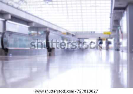 Movable conveyor belt in Bangkok airport, blurred background of persons walking through, concept of light 