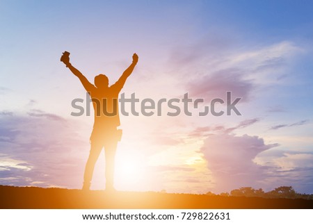 Silhouette of man standing enjoying sunset / sunrise evening sky background, Happiness and active life Concept.