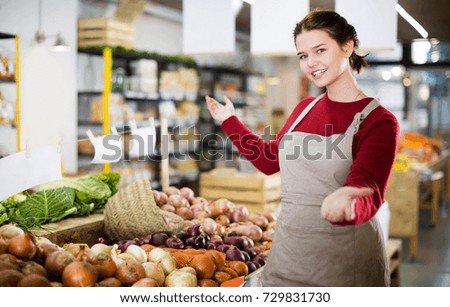 Portrait of positive girl selling onion and smiling