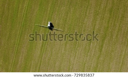 Aerial photo above crop spraying tractor pesticide chemical farm field agriculture