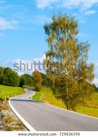 Winding asphalt road in rural landscape of Sumava Mountains, Czech Republic.