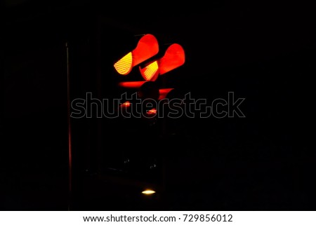 Red traffic light at the junction in the city with dark night background