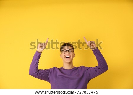 Emotional teenager boy in casual clothes on color background