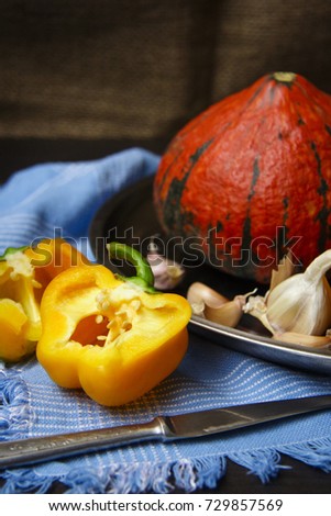 Pumpkin hokkaido and sweet yellow pepper with garlic cloves in rustic style