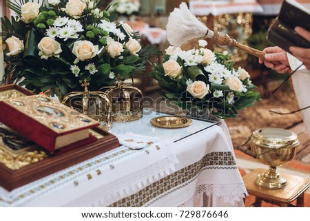 golden crowns and bible and wedding ring on altar in church at wedding matrimony. traditional religious wedding ceremony