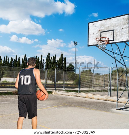 basketball player in a playground under a cloudy sky