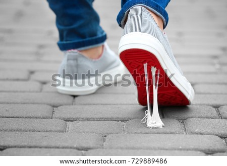 Foot stuck into chewing gum on street. Concept of stickiness Royalty-Free Stock Photo #729889486