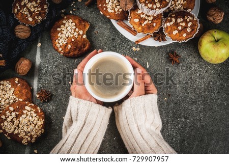 Autumn winter pastries. Vegan food. Healthy cookies, muffins with nuts, apples, oat flakes. Cozy atmosphere, warm blanket, girl drink coffee, hands in picture. Dark stone table. Copy space top view