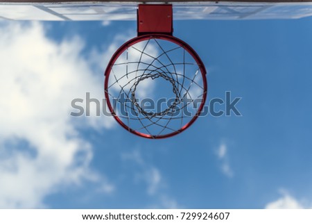Bottom view of basketball hoop on blue sky background