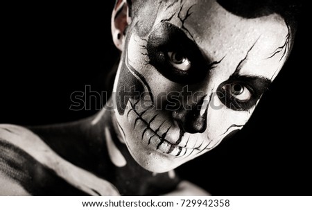 Isolated on black, closeup picture, young brunette caucasian pretty woman with scull body art, grey eyes, turned head