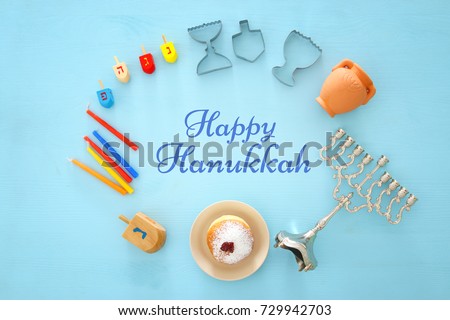 Top view image of jewish holiday Hanukkah background with traditional spinnig top, menorah (traditional candelabra) and burning candles