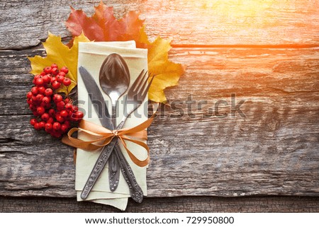 Rustic wooden background with cutlery, arrangement autumn leaves. Thanksgiving vintage style greeting card. Thanksgiving day concept. 