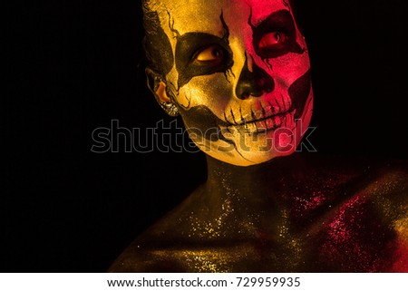 Isolated on black, closeup picture, toned red and yellow, beautiful young blonde caucasian woman with scull body art, grey eyes