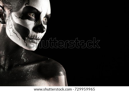 Isolated on black, closeup picture, beautiful young blonde caucasian woman with scull body art, grey eyes, position at left, look at right