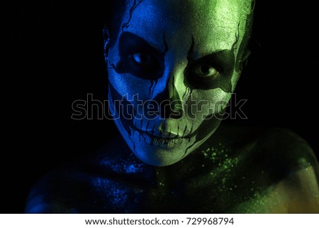 Isolated on black, closeup picture, toned green and blue, beautiful 
creepy young blonde caucasian woman with scull body art, grey eyes