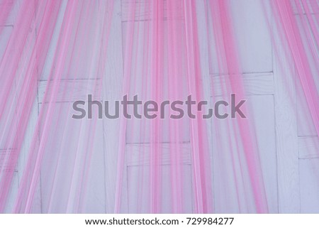 Thin pink curtains.