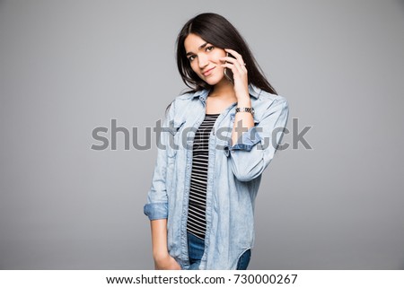 Portrait of brunette cute woman with beautiful and healthy toothy smile, with hand on chin. Young happy pretty woman wearing black sweater on light grey background. Positive and happiness mood.