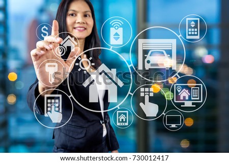 Business woman in formal wear working  with smart home assistant property icon on futuristic virtual screen / Modern real estate concept