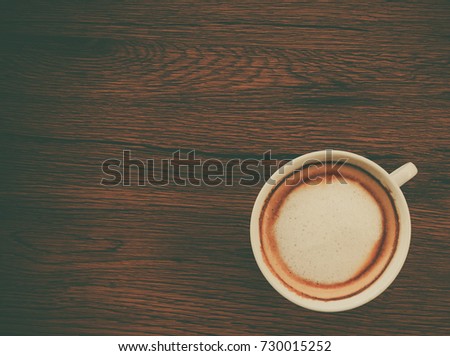 Close up cup of cappuccino coffee put on brown wooden tabletop at the cafe shop