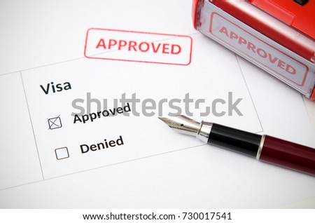 Visa and approved stamp on a document form. Immigration and travel concept Royalty-Free Stock Photo #730017541