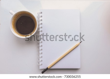 A notebook, a pencil, a Cup of coffee on a white background. Top view