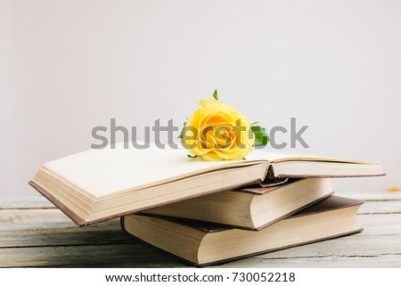 Yellow rose as sign of romance in a vintage book on table