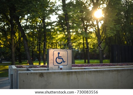 Wheelchair sign in park with sunshine through the trees