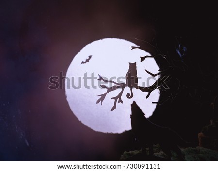 Halloween concept. silhouette of tree,cat and wolf on full moon. Magic style.