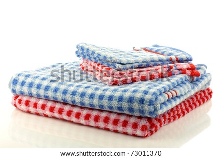 stacked colorful checkered bathroom towels and wash cloths on a white background