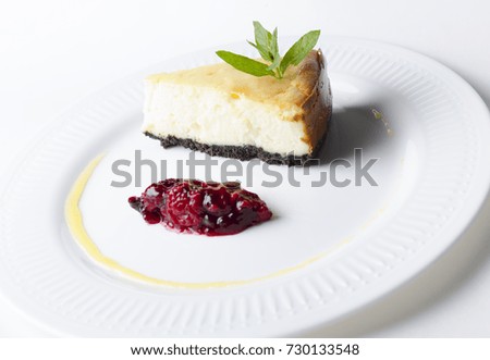 Classic cheesecake with cherry sauce on a white plate
