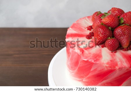 Cake red velvet with whipped red cream, fresh strawberries on dark wooden table. Picture for a menu or a confectionery catalog. Close up.