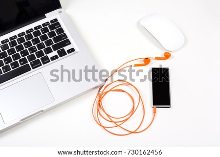 Orange and red color earphone with laptop on white background.