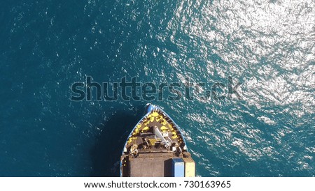 An almost empty container ship sails on open water with no containers or cargo - aerial view
