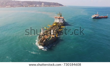Suction Dredger ship working near the port - with mud, Pollution, brown Muddy water - aerial shot