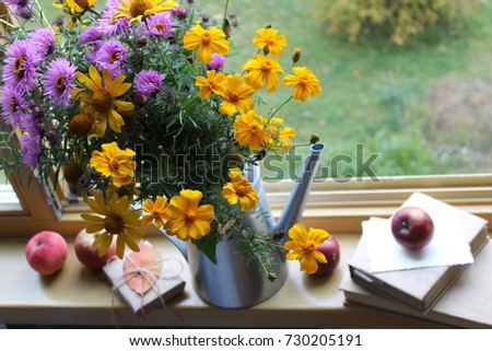 autumn background / bouquet of  flowers and  books on the windowsill