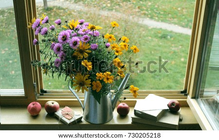autumn background / bouquet of  flowers and  books on the windowsill